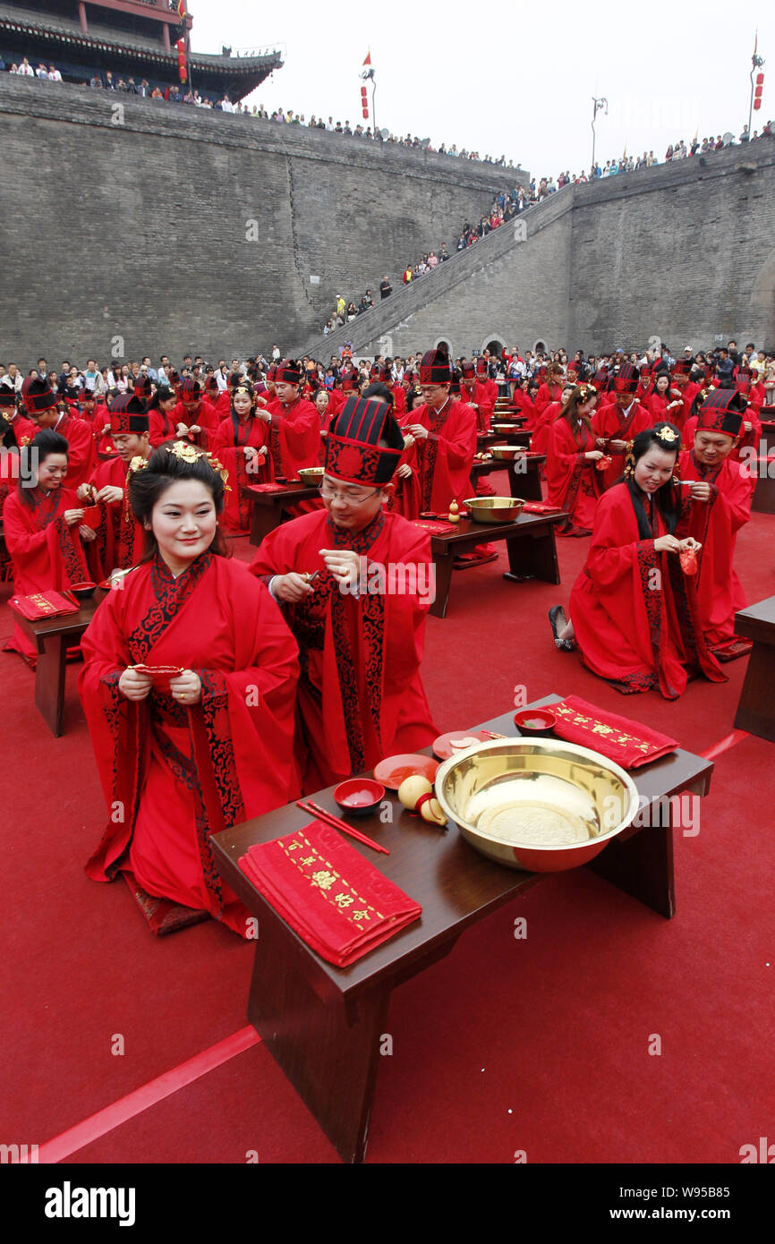 Mariés en Ciseaux poils de leur épouse dans le cadre de rites nuptiaux chinois ancien groupe au cours d'une cérémonie de mariage dans la ville de Xian, dans les Chines Shaan Banque D'Images