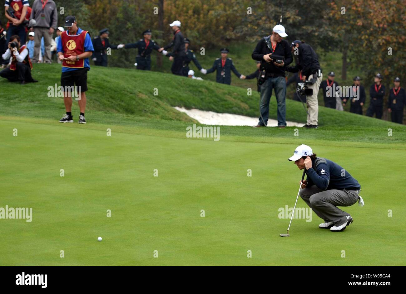 Rory McIlroy de l'Irlande du Nord, à l'avant, estime un putt comme il est en concurrence avec Tiger Woods de l'a déclaré au cours de la duel à Jinsha Lake golf Banque D'Images