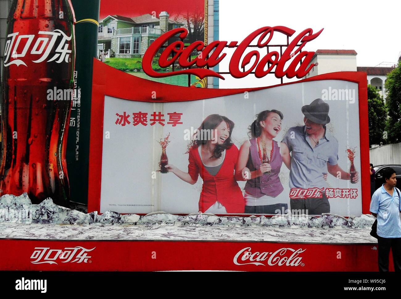 --File--Un piéton est vu par un panneau publicitaire pour Coca-Cola à Yichang, Chine centrale de la province du Hubei, 25 janvier 2012. Une cérémonie d'ouverture a eu lieu je Banque D'Images