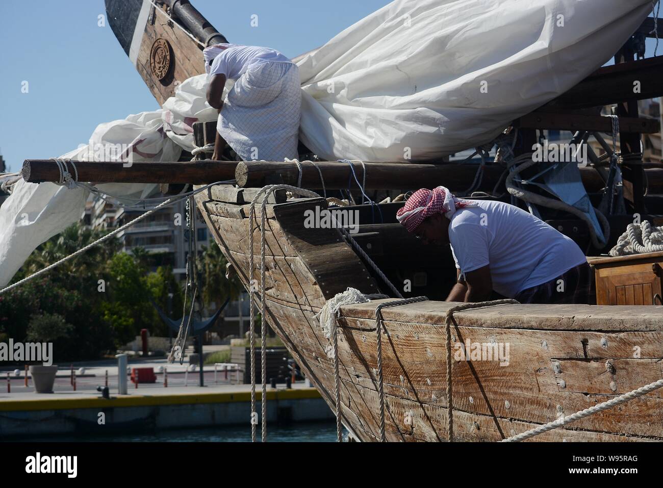 Les membres de l'équipage du navire Mubaraki préparer le navire de s'écarter de la Marina Zeas, Le Pirée pour le port de l'île de Corfou.Le navire est en train de faire un voyage de deux ans la promotion de la Coupe du Monde 2022 Pays du Golfe persique, l'Océan Indien et la Méditerranée. Coupe du monde 2022 aura lieu au Qatar. Banque D'Images