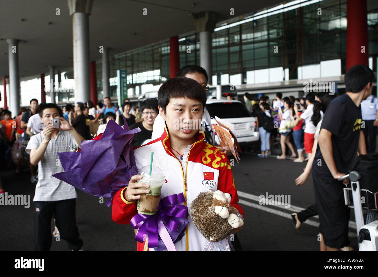 Champion de tennis de table olympique chinoise Guo Yue (C en rouge) est photographié à l'Aéroport International de Pékin à Beijing, Chine, 10 août 2012. Banque D'Images