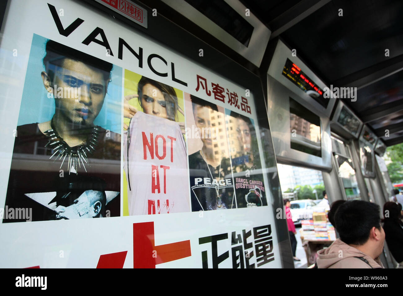 --FILE--passagers attendre devant une publicité pour vêtements Vancl à une station de bus à Shanghai, Chine, le 27 avril 2012. Certains des mondes leadin Banque D'Images