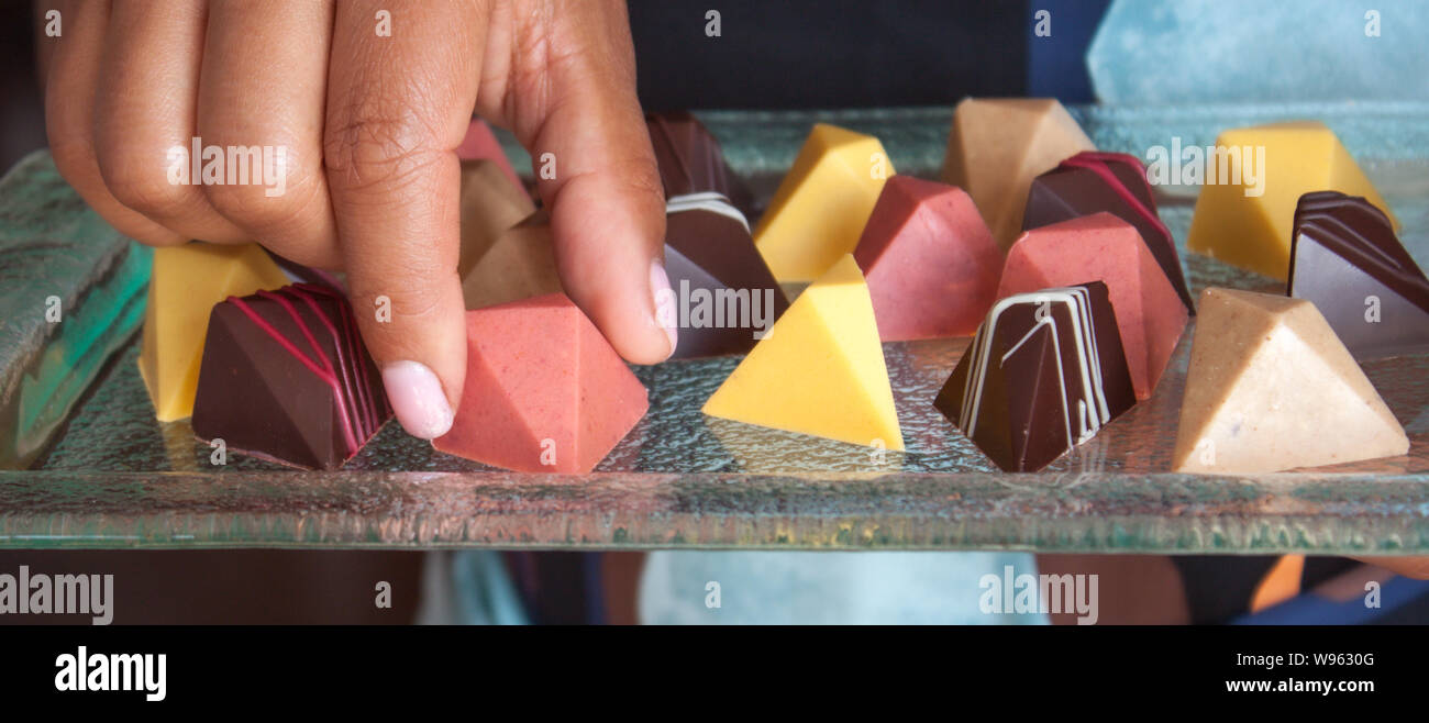 Chocolat pralines vegan colorés en verre sur plateau. Banque D'Images