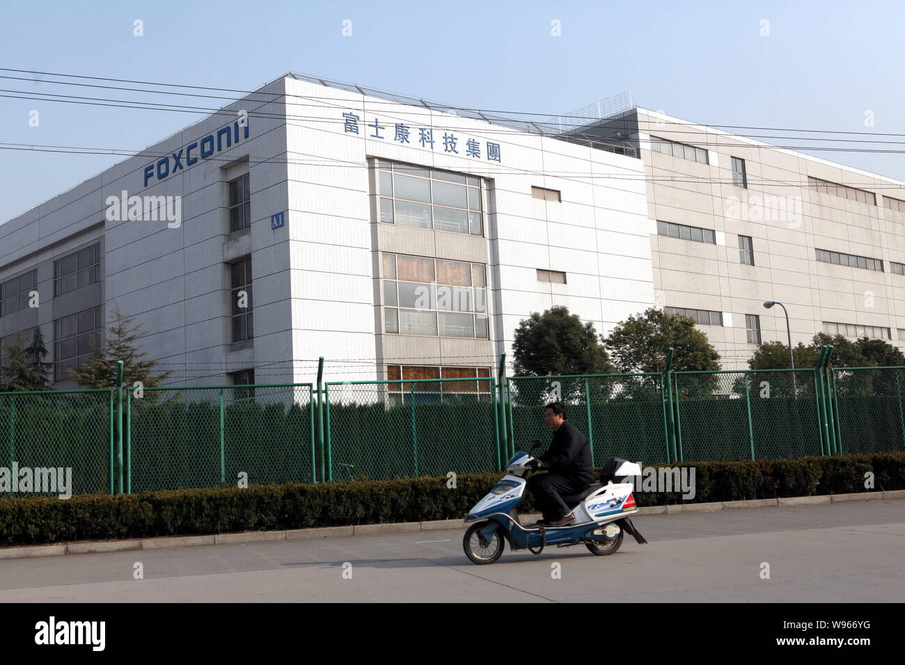 --File--Un homme chevauche son vélo électrique passé une usine de Foxconn dans la Zone Industrielle de Songjiang à Shanghai, Chine, 21 février 2011. Foxconn, l'o Banque D'Images
