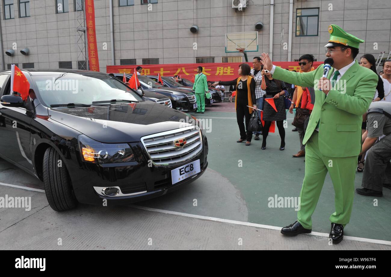 Le milliardaire philanthrope chinois Chen Guangbiao, droite, Président de Jiangsu Road Ressources Recyclage Co., Ltd., des vagues à ses fans Geely conduite E Banque D'Images