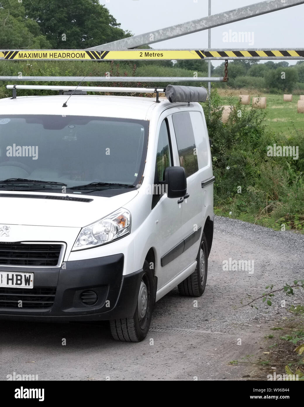 Août 2019 - Peugeot Expert converti en un jour camper van conduire sous un parking barrière, restriction de hauteur Banque D'Images