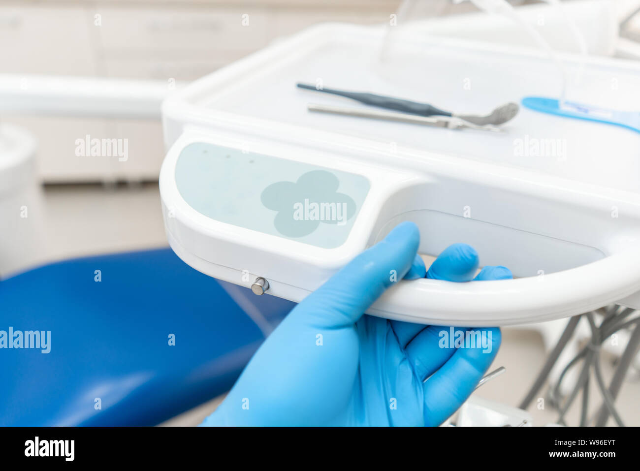 La main du dentiste dans la boîte à gants appuie sur les boutons de contrôle du président.. Travaux dentaires en clinique. Opération, remplacement des dents. Médecine, santé Banque D'Images