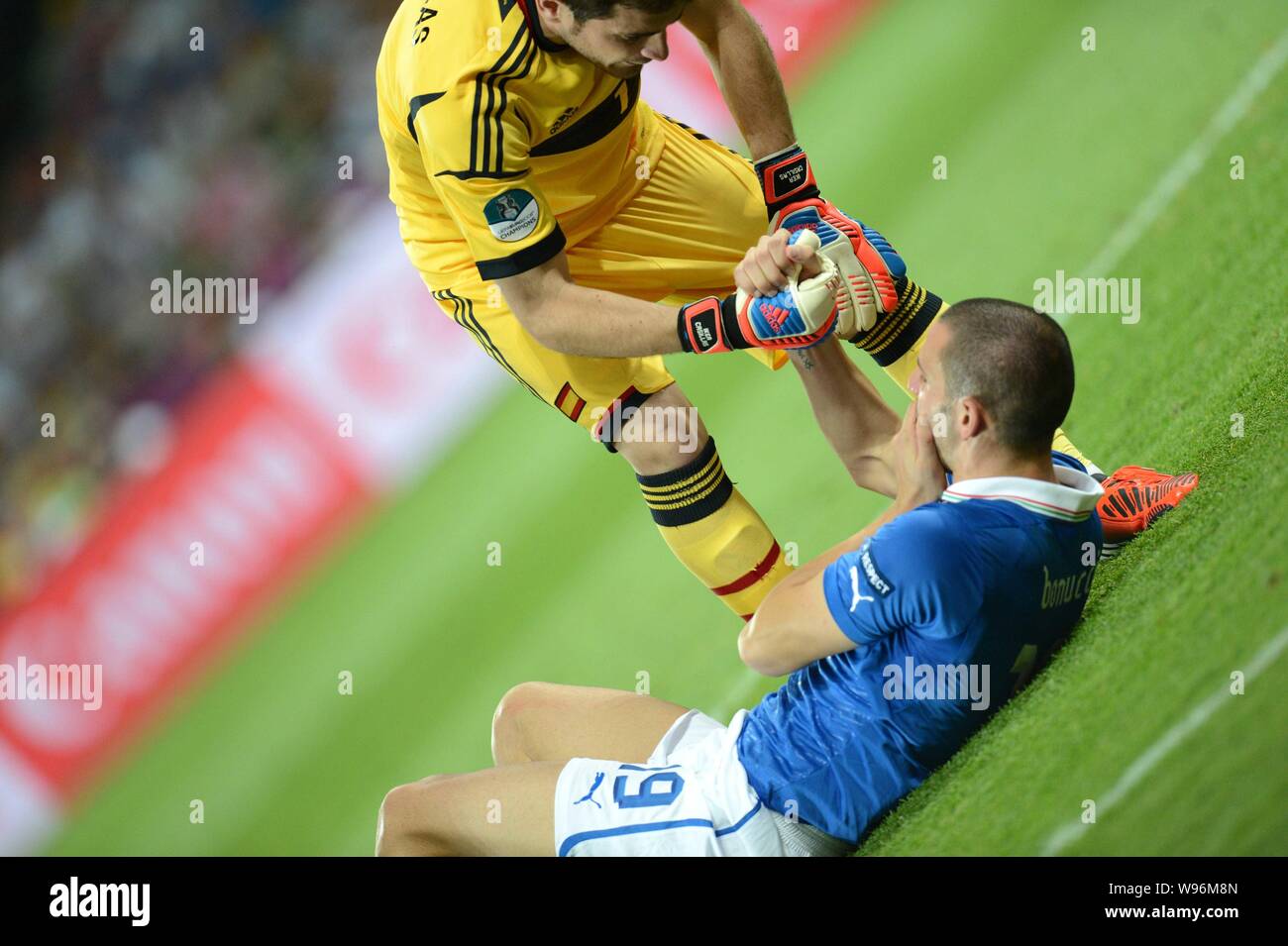Iker Casillas le gardien de l'Espagne contribue à Leonardo Bonucci de l'Italie de se lever le dernier match du championnat d'Europe de Football UEFA 2012 à Kiev Banque D'Images