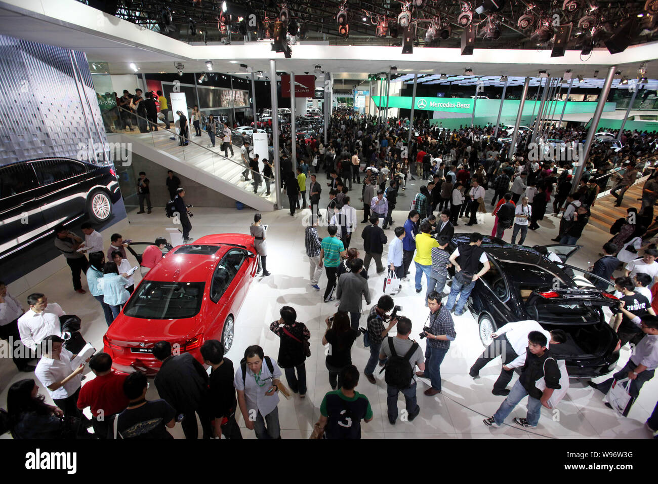 Visiteurs se pressent autour de BMW (avant) et Mercedes-Benz Cars lors de la 12e exposition Internationale Automobile de Beijing, connu sous le nom de Auto China 2012, à Bei Banque D'Images