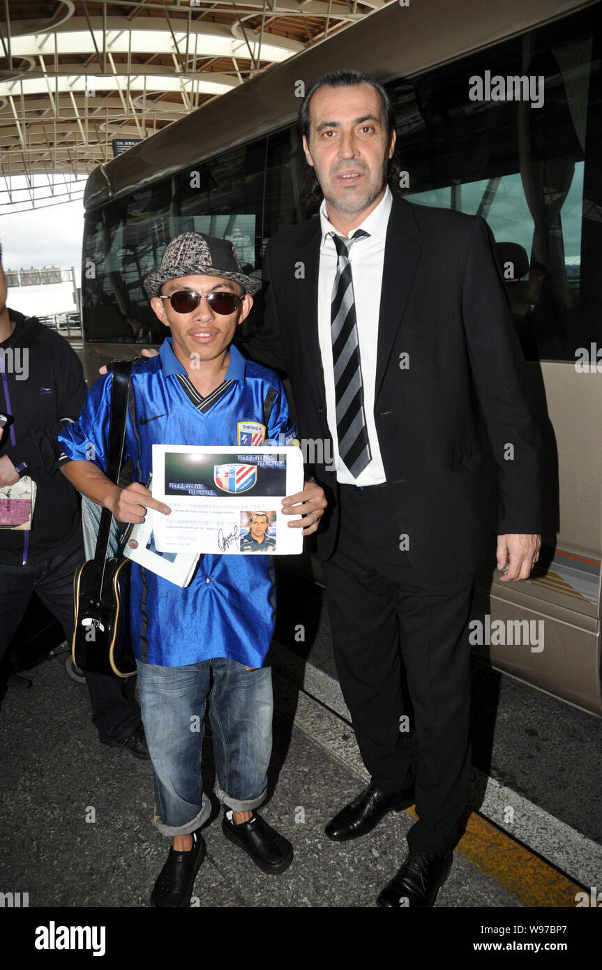 Entraîneur de football argentin Sergio Batista, droite, pose avec une fan après son arrivée à l'Aéroport International de Shanghai Pudong à Shanghai, Chine, 25 mai Banque D'Images