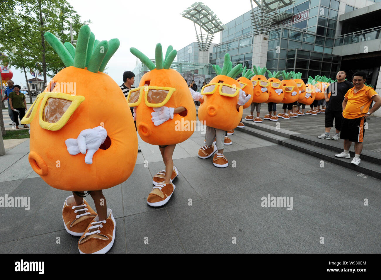 Pan Kun et ses amis déguisés en carottes de danse à la chanson thème du hit TV show datant de Jiangsu Si vous êtes l'un à l'Qingdaos Aofan Squ Banque D'Images