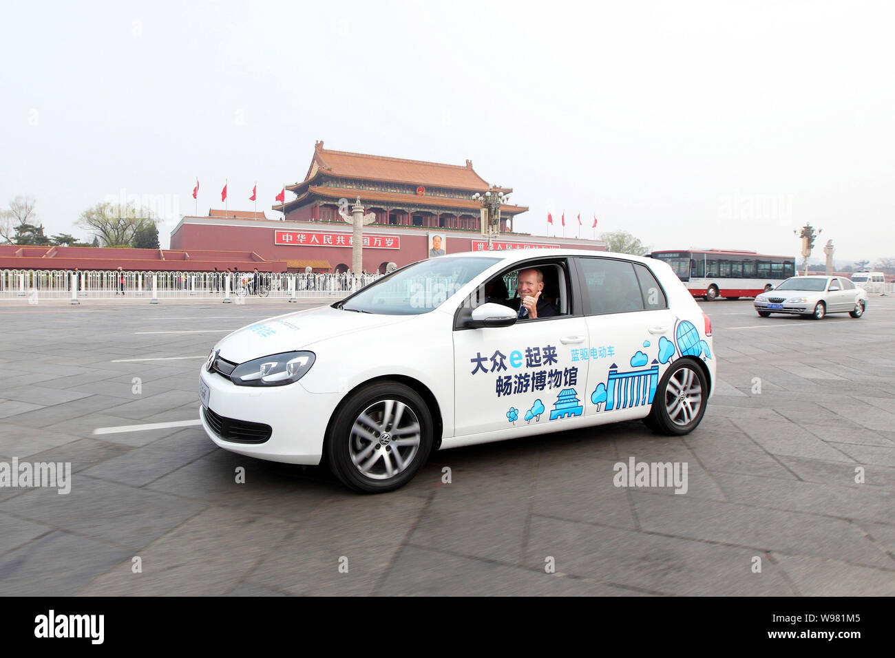 Dr. Karl-Thomas Neumann, président-directeur général de Volkswagen Group Chine, conduit une voiture électrique de Golf passé place Tiananmen à Beijing, Chine, 6 avril 2011 Banque D'Images