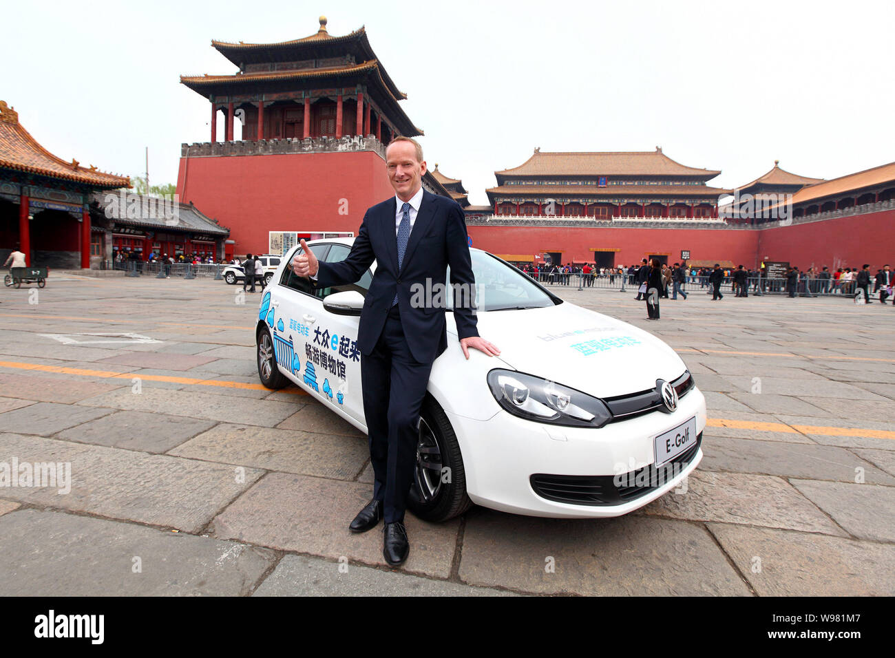 Dr. Karl-Thomas Neumann, président-directeur général de Volkswagen Group Chine, pose à côté d'une voiture électrique de golf en face de la Cité Interdite à Beijing, Chi Banque D'Images