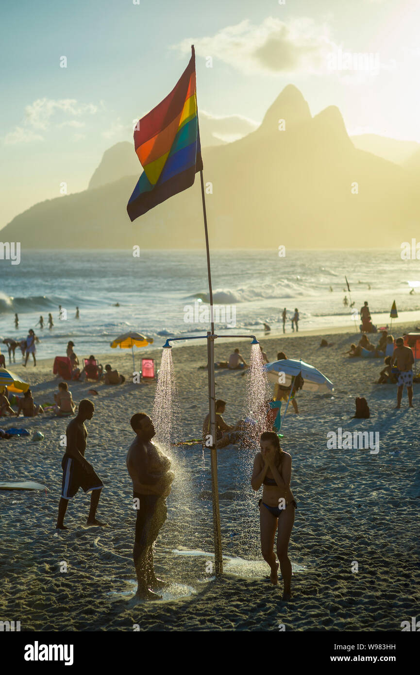 RIO DE JANEIRO - Février, 2018 : Amateurs de douche sous une gay pride drapeau arc-en-ciel sur la plage d'Ipanema, un quartier connu pour la diversité et la tolérance. Banque D'Images