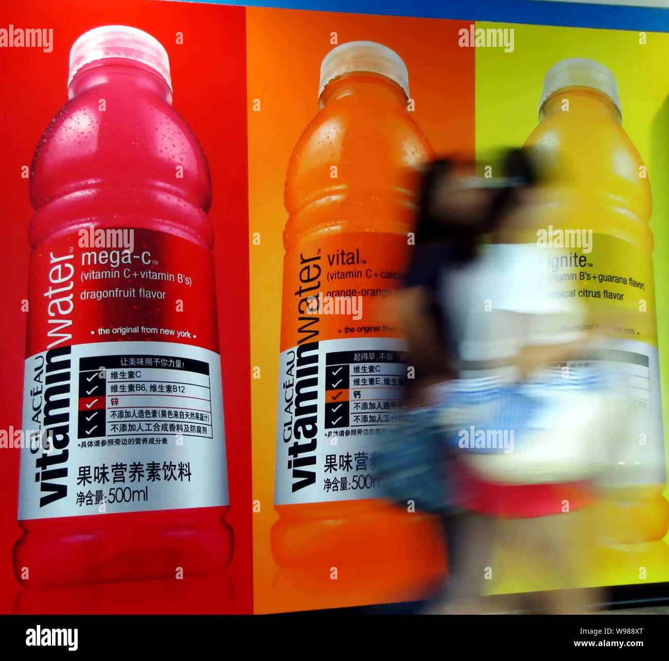 Les piétons devant une¨¦au Glac de vitamine Eau produite par Coca-Cola à Yichang, Chine centrale la province du Hubei, 12 octobre 2011. La f Banque D'Images