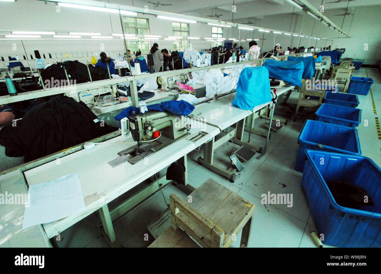 Certains travailleurs chinois faire des vêtements à exporter vers les États-Unis et l'Europe à un atelier à moitié vide de Jiujiang Sp. z o.o. Garment Factory en Jiujia Banque D'Images