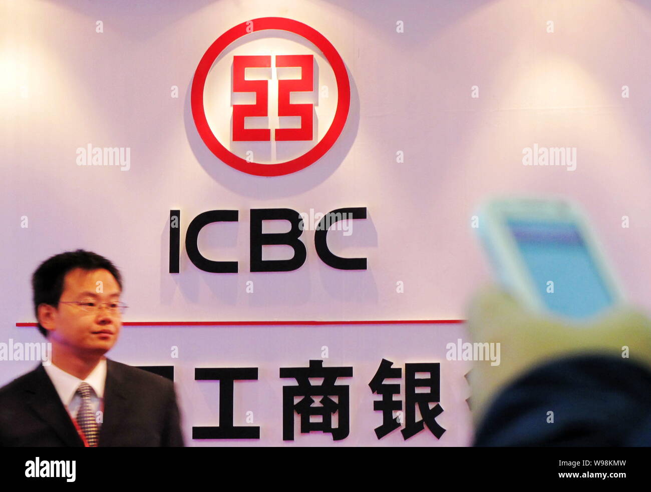 --File--Un homme est connu sous le grand logo de Banque industrielle et commerciale de Chine (ICBC) lors d'une exposition à Shanghai, Chine, 19 octobre 2010. Banque D'Images