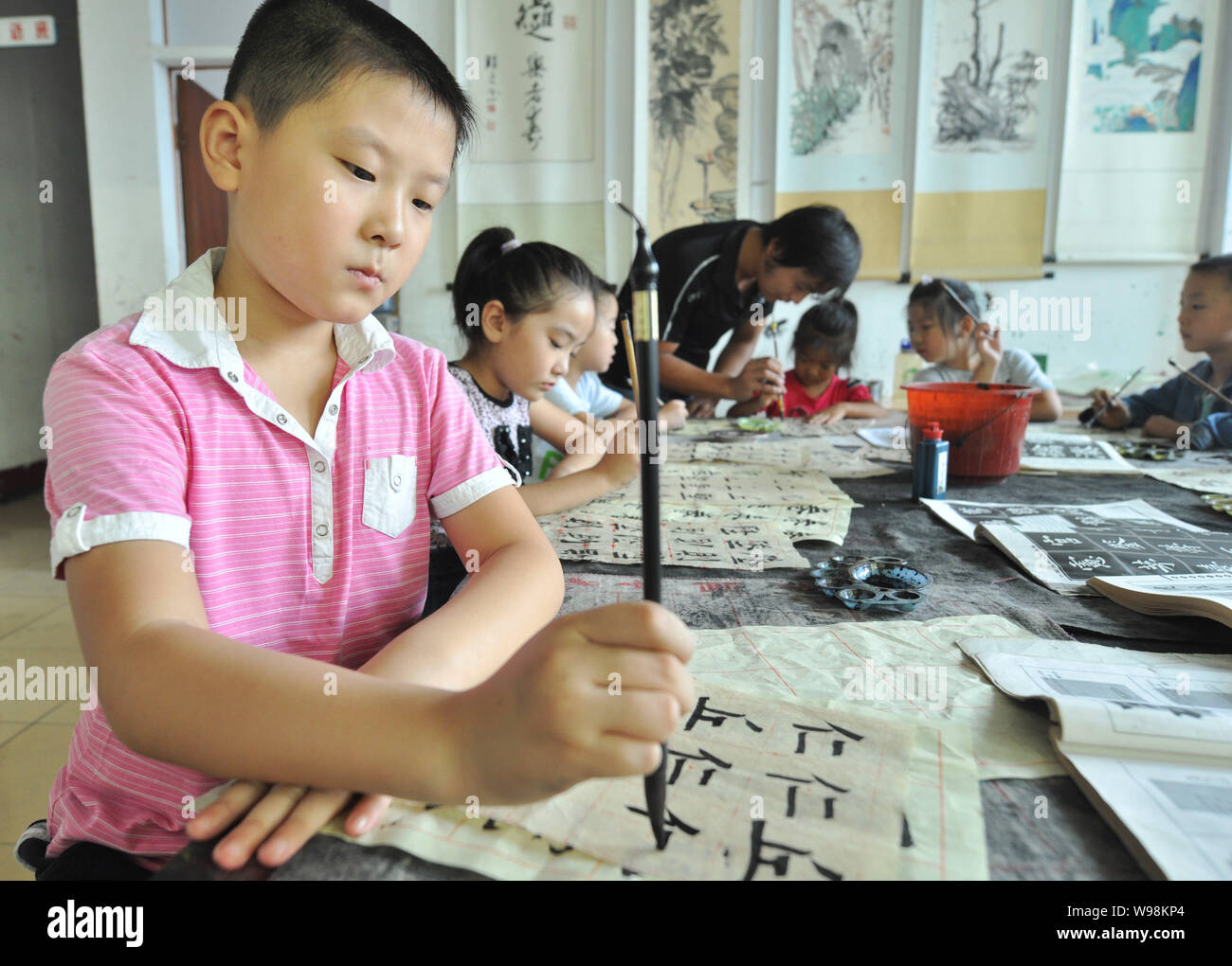 Les élèves apprennent la calligraphie dans une classe dans Zhouping de l'Est, la province de Shandong, Chine, 29 août 2011. La calligraphie, la façon traditionnelle de l'enregistrement, est grad Banque D'Images