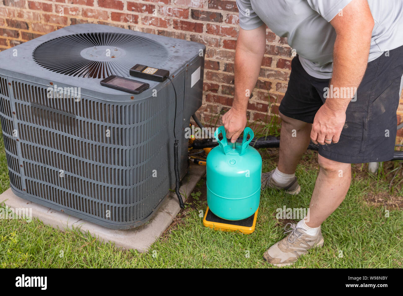 Technicien de maintenance d'air Conditioenr ajoutant refrigerent Banque D'Images