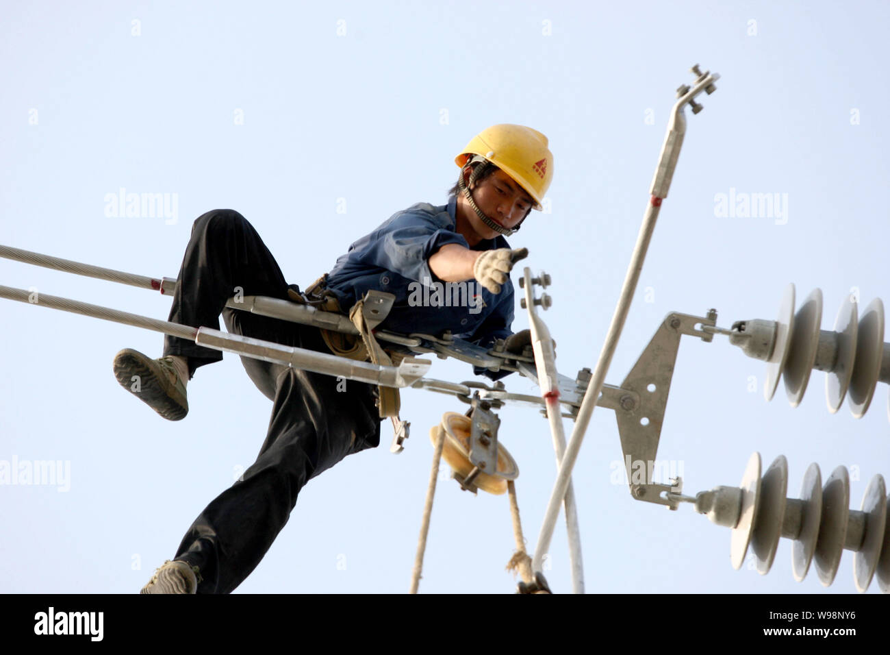 Une mise à niveau des lignes de transport d'électricité électricien chinois dans la ville de Huaibei, à l'est la province de l'Anhui, Chine 17 mai 2011. Une vague de pannes de matériel roulant qui a commencé ea Banque D'Images