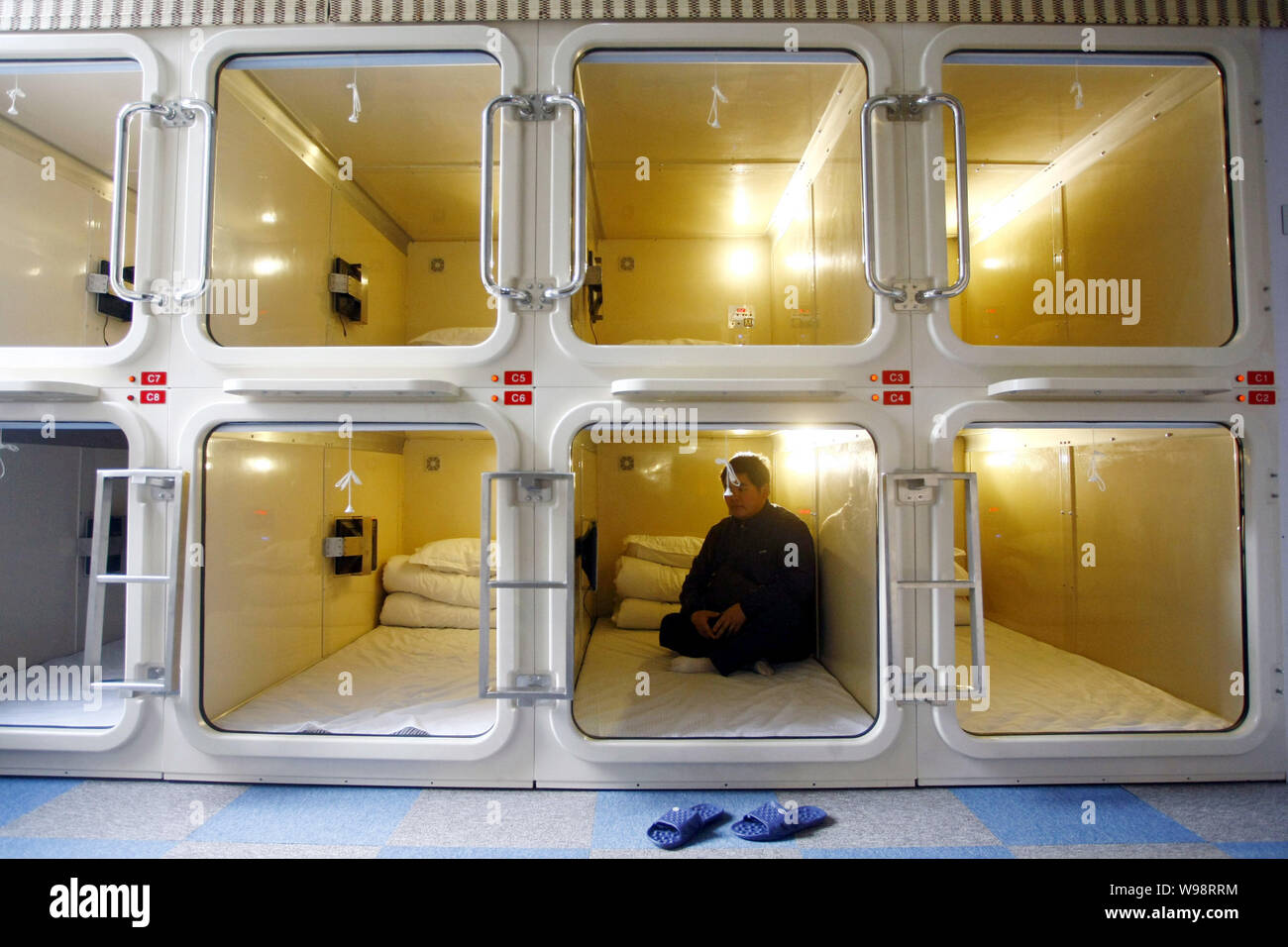 Un Chinois repose dans une chambre de taille moyenne du cabinet à Chines  premier hôtel capsule de Shanghai, Chine, le 10 janvier 2011. Chines  premier hôtel capsule sera op Photo Stock - Alamy