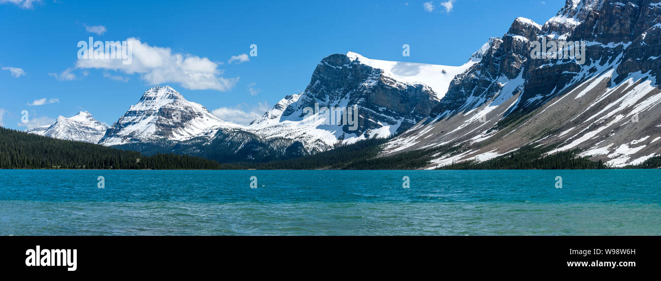 Le Lac Bow - une vue panoramique de printemps encore des montagnes enneigées s'élevant au bord du pittoresque lac Bow, Banff National Park, Alberta, Canada. Banque D'Images
