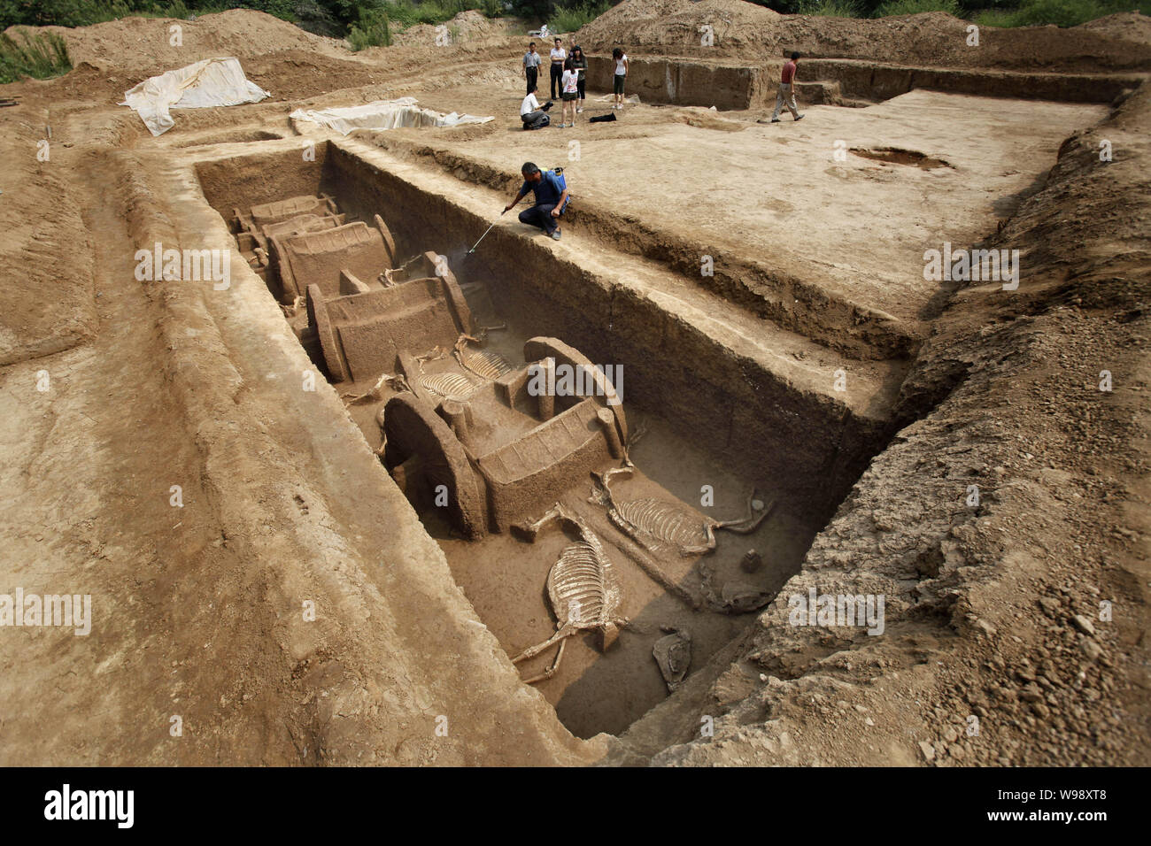Le personnel d'un opérateur arrose afin de maintenir l'humidité des restes de chars et de chevaux de l'Est de dynastie Zhou (770BC-221BC) découvert dans le centre de la Chine, Banque D'Images