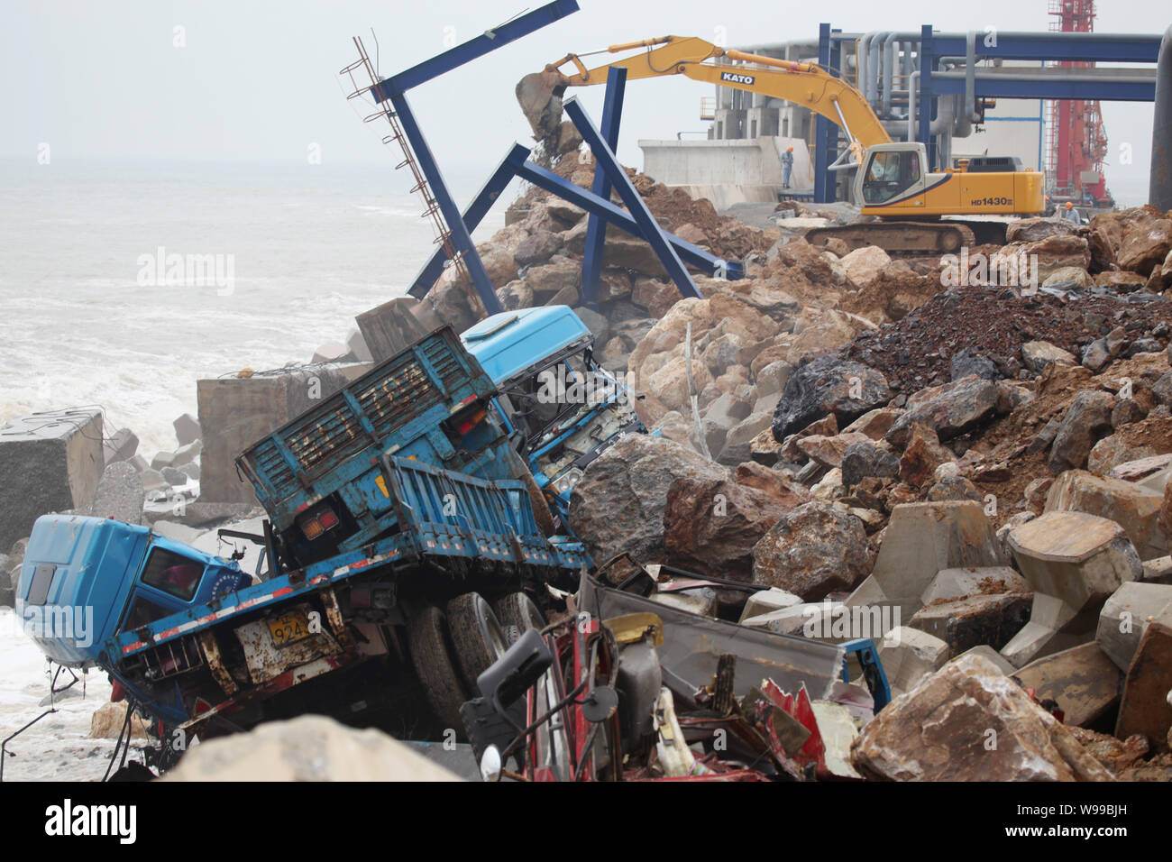 --FILE--travailleurs renforcer la digue de protection violés par les vagues causées par le typhon Muifa Fuija à l'usine chimique dans le nord-est de la municipalité de Chines L Banque D'Images