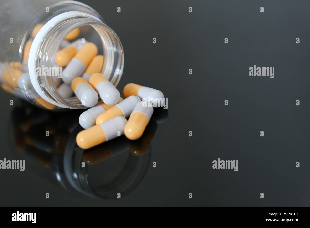 Comprimés dans une bouteille, des médicaments dans des capsules sur une table en verre. Concept de pharmacie, antibiotiques, vitamines Banque D'Images