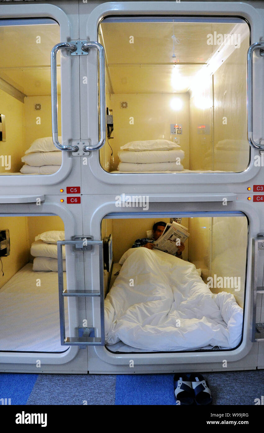 Un Chinois lit journal de sa chambre à l'hôtel capsule de Shanghai, Chine,  le 7 janvier 2011. Le premier hôtel capsule soit ouverte dans le Photo  Stock - Alamy