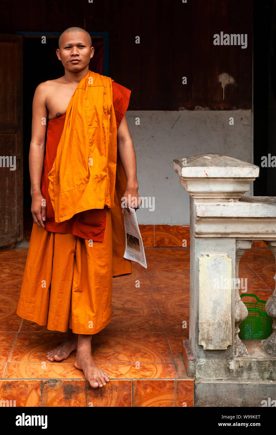 Portrait d'un moine bouddhiste traditionnelle avec robe orange dans un temple building à Siem Reap, Angkor, Cambodge région. Banque D'Images