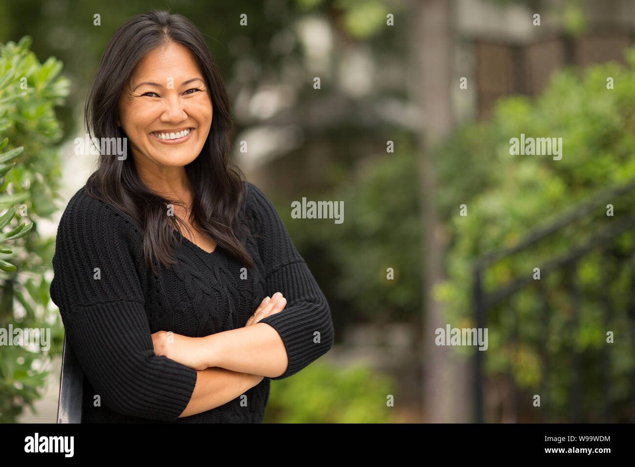Portrait d'une femme asiatique assise à l'extérieur. Banque D'Images