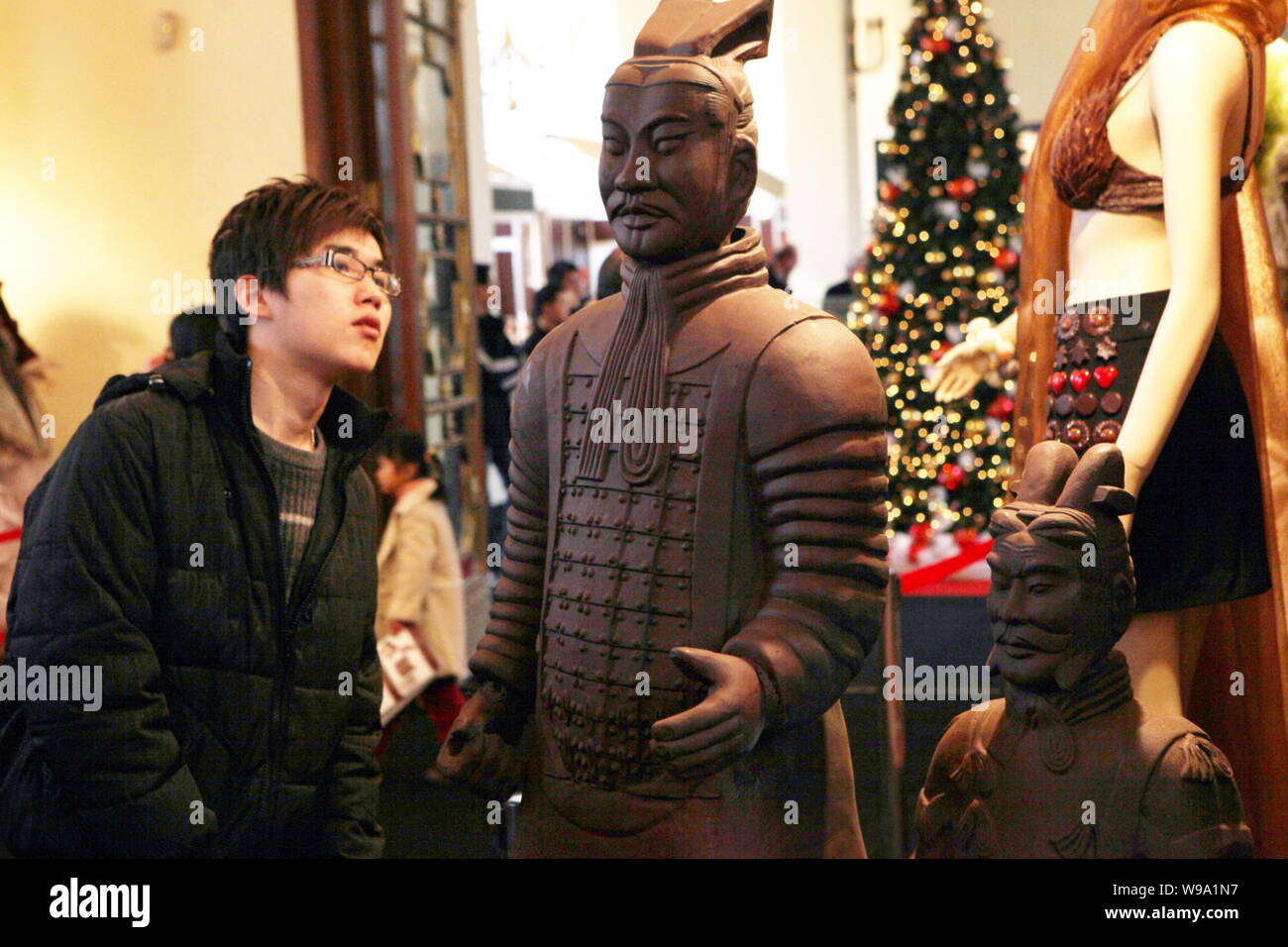 Les visiteurs regarder-chocolat fait des répliques des guerriers de terre cuite pendant le salon du chocolat, Salon du Chocolat, à Shanghai, Chine, 21 janvier 2010. Banque D'Images