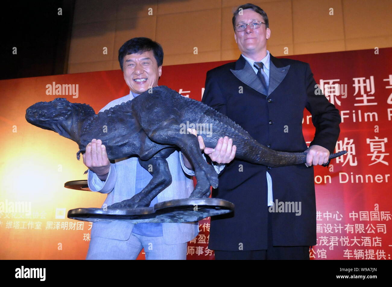 L'acteur Jackie Chan à Hong Kong (à gauche) et New Zealand Film maker Richard Taylor montrent un modèle de dinosaure au cours d'une vente aux enchères le dîner de Shanghai Inte Banque D'Images
