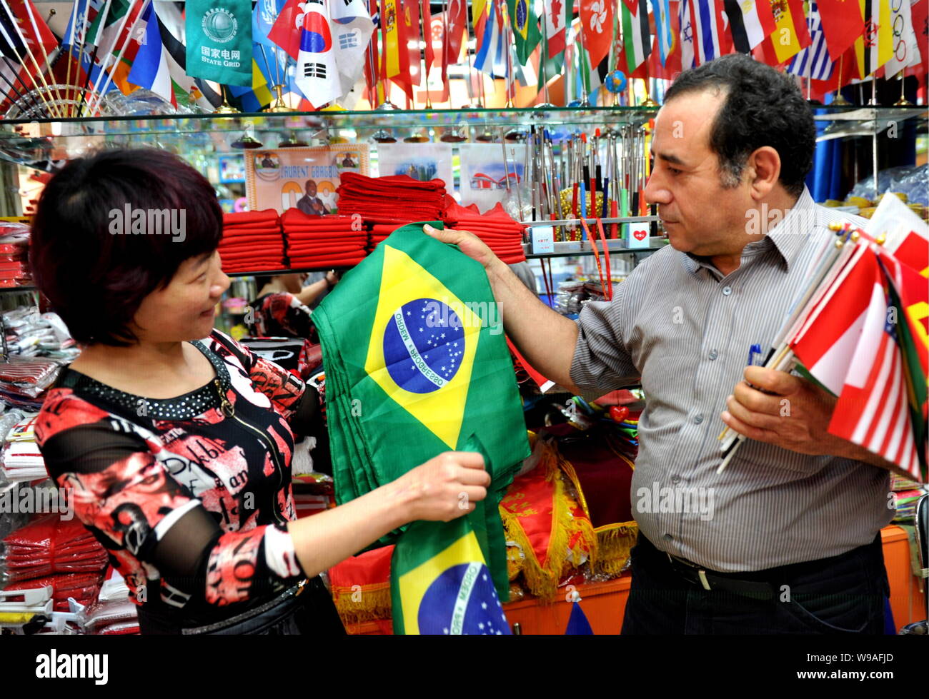 --FILE--un marchand chinois, gauche, négocier avec un acheteur étranger sur les ventes de drapeaux brésiliens dans une boutique à l'Yiwu International Trade City dans Yi Banque D'Images