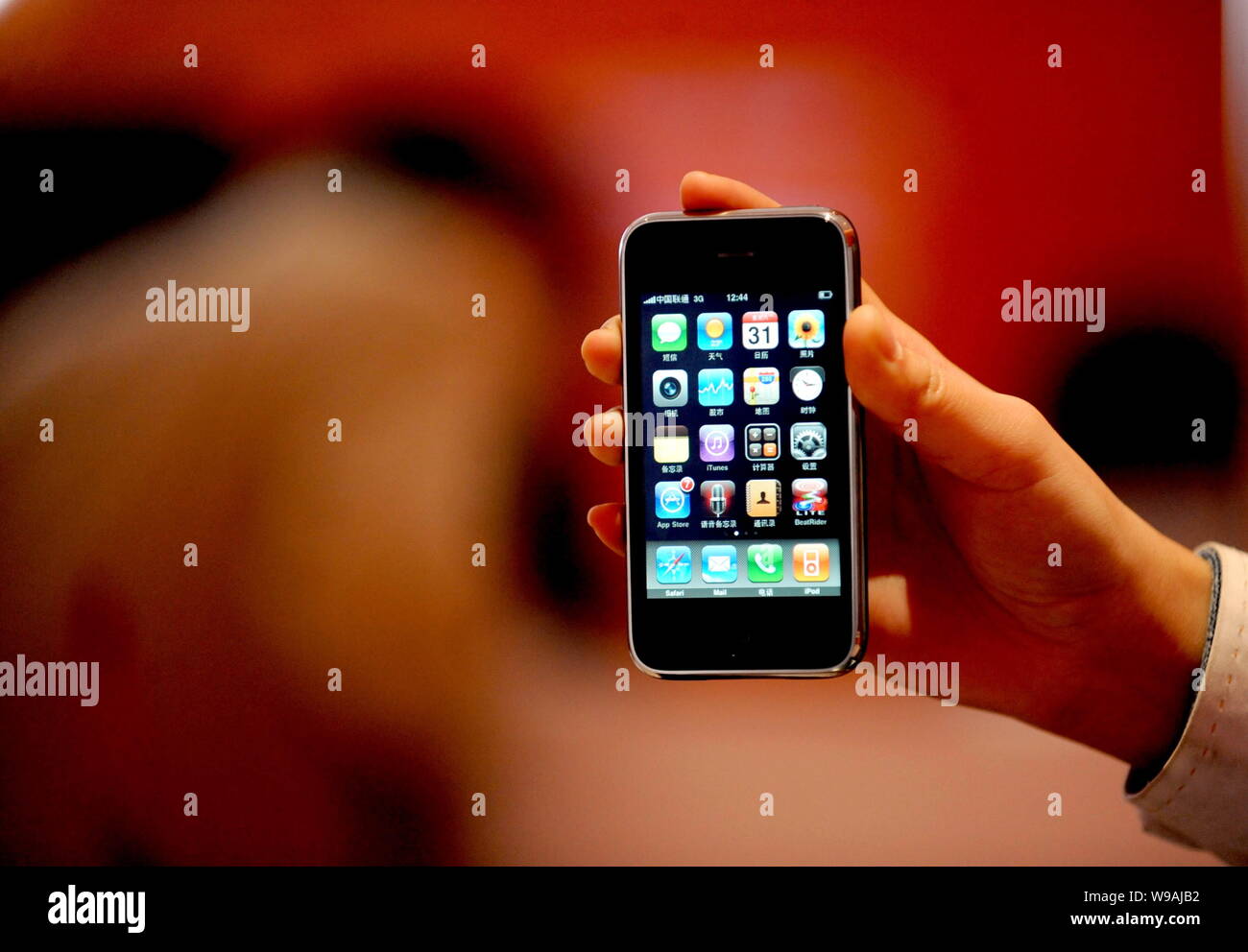 --FILE--un employé chinois montre un iPhone 3GS téléphone mobile à China Unicom business hall dans la ville de Shenyang, province de Liaoning, Chine du Nord-Est 31 O Banque D'Images