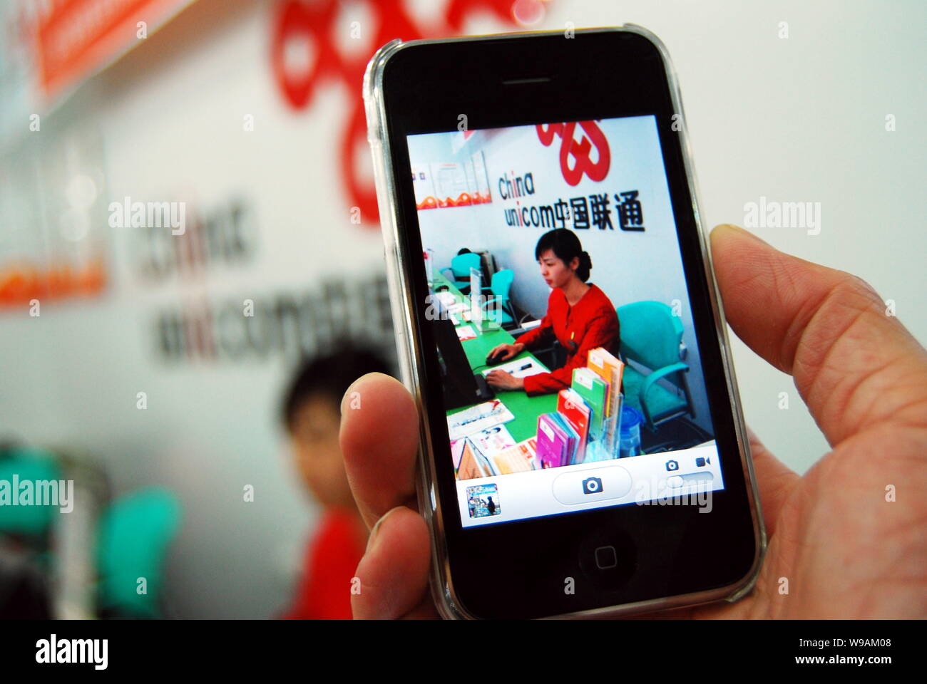 --FILE--un employé chinois utilise un iPhone 3GS téléphone mobile à China Unicom business hall dans la ville de Chenzhou, province du Hunan, Chine centrale, 8 novembre Banque D'Images