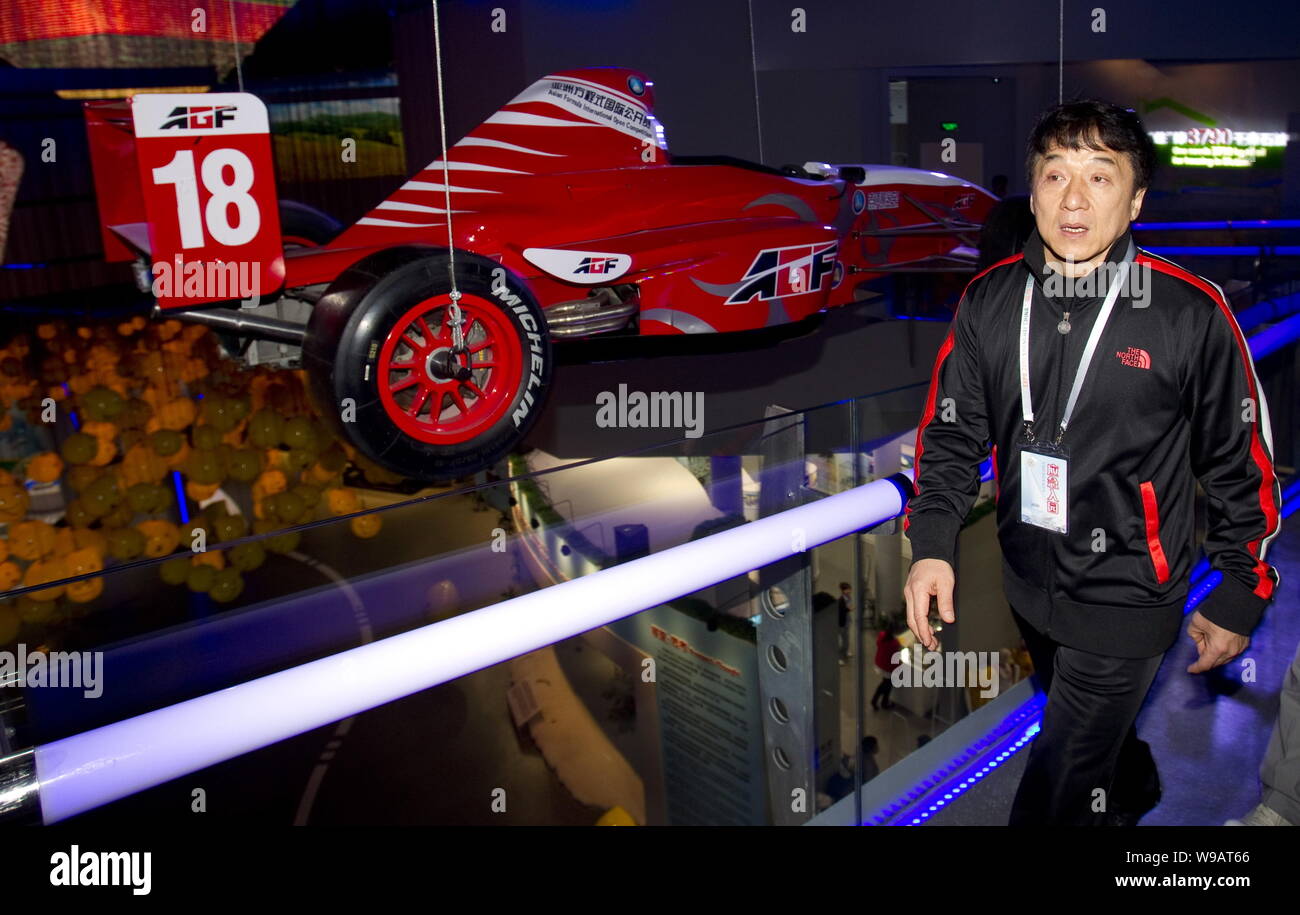 Superstar kungfu Hong Kong Jackie Chan passe devant une voiture de course à l'intérieur du pavillon de l'huile dans le monde site de l'Expo de Shanghai, Chine, 13 mai 2010. Jacki Banque D'Images Superstar kungfu Hong Kong Jackie Chan passe devant une voiture de course à l'intérieur du pavillon de l'huile dans le monde site de l'Expo de Shanghai, Chine, 13 mai 2010. Jacki Banque D'Images