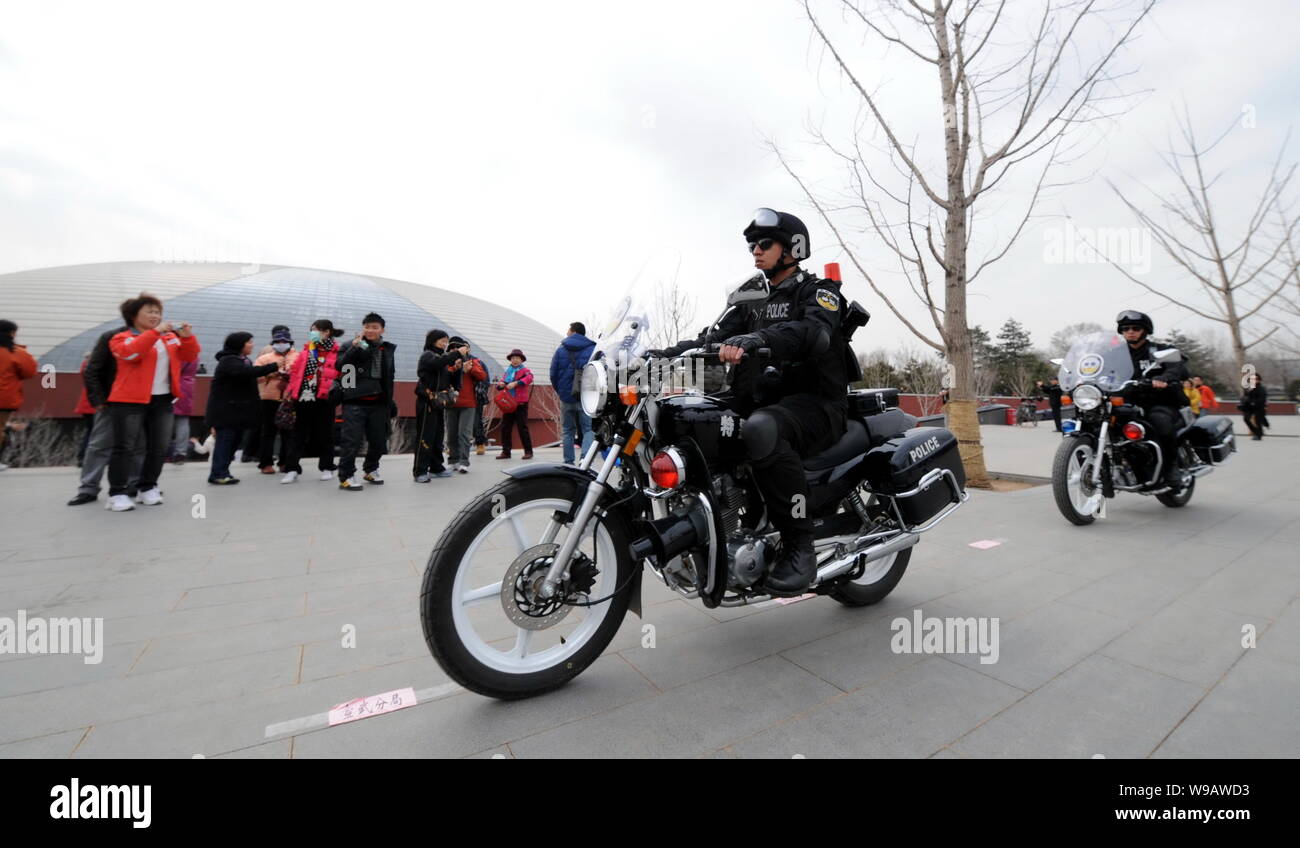Entraînement de policiers chinois armés patrouillant la moto passé National Centre for the Performing Arts (NCPA), également connu sous le nom de National Grand Theatre, Banque D'Images