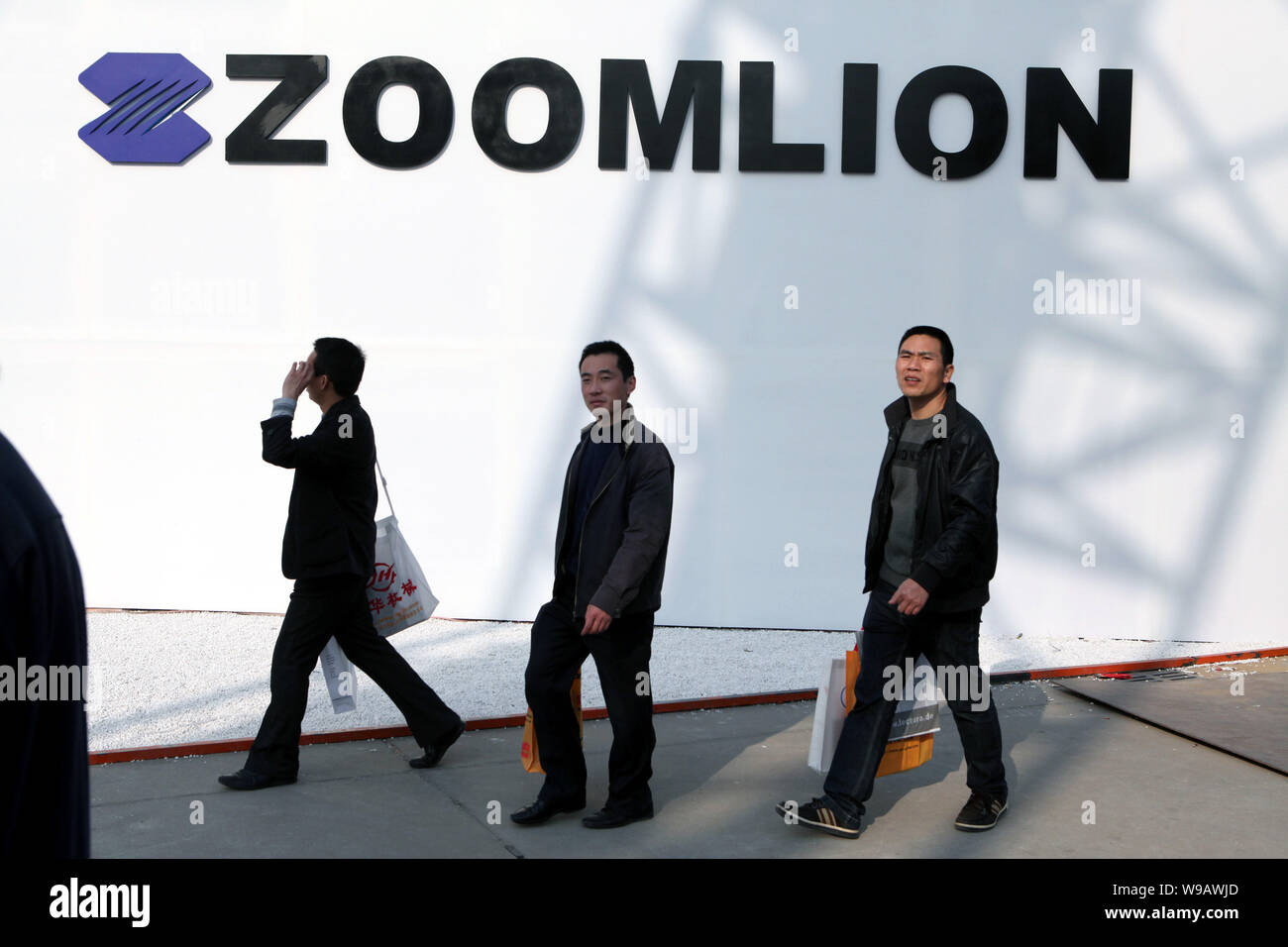 Les visiteurs passent devant une publicité de Changsha Zoomlion Heavy Industry Science & Technology Development Co. pendant la Foire commerciale internationale de 2010 Banque D'Images