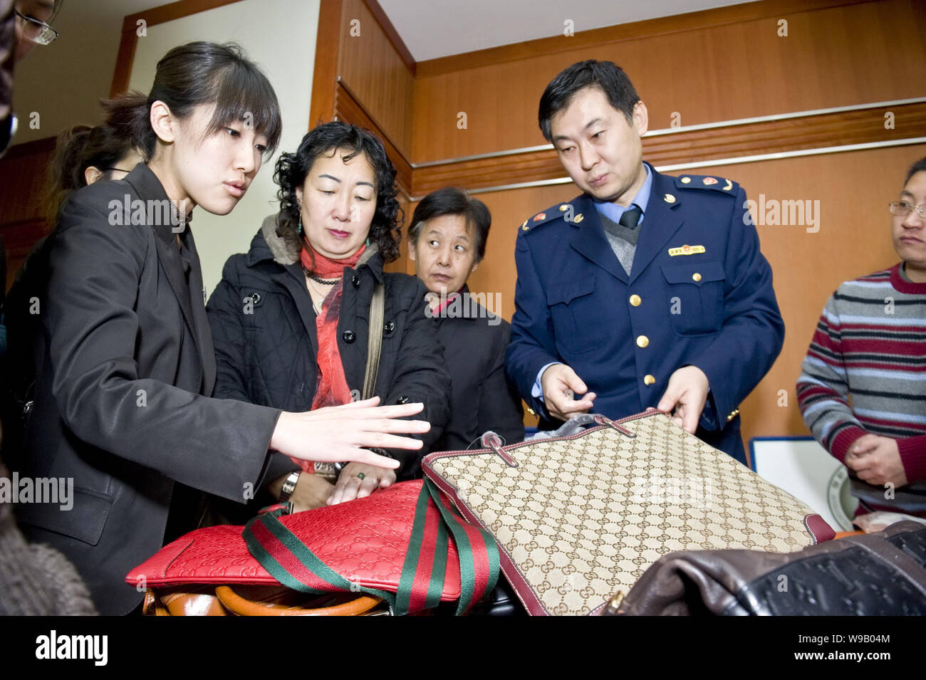 --FILE--chinois les agents de la montrer de faux sacs Gucci pour les résidents locaux pour leur apprendre à distinguer les vrais et faux produits à Beijing Banque D'Images