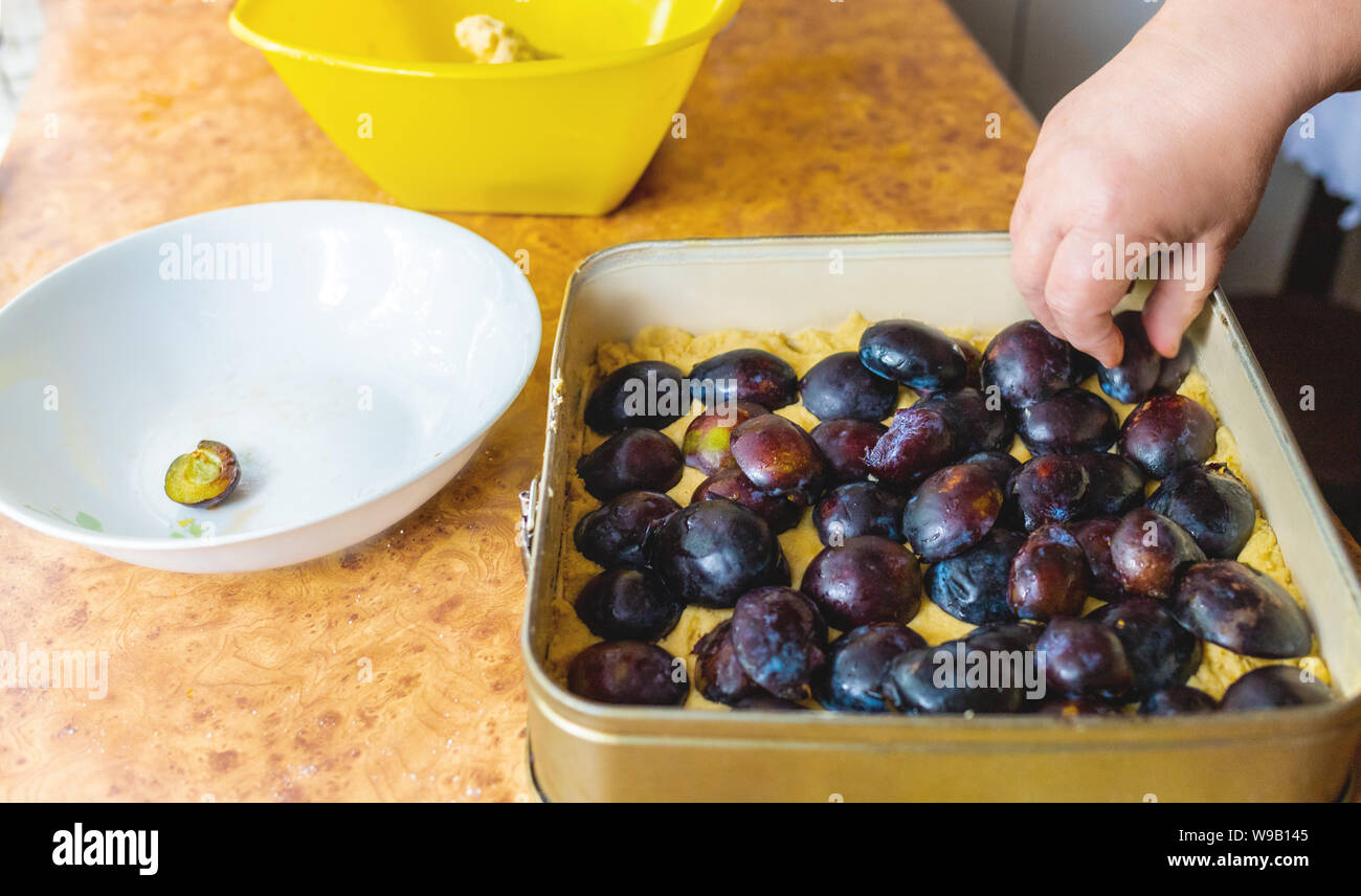 La grand-mère gâteau aux prunes. Des pâtisseries maison. Un gâteau aux fruits. Part d'une femme âgée à travaux cuisine Banque D'Images