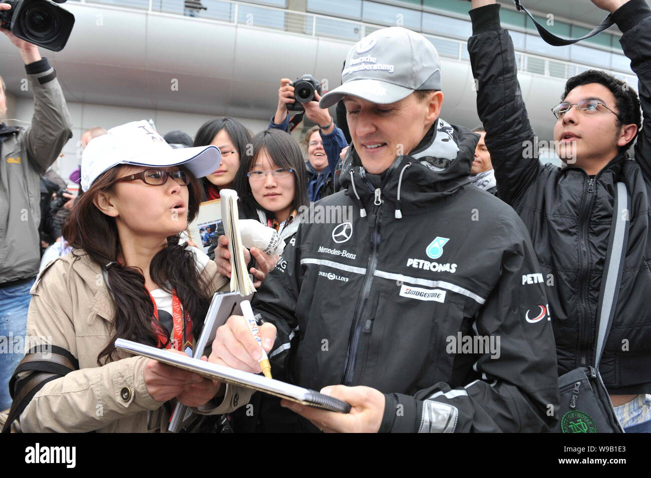 L'allemand pilote de F1 Michael Schumacher de l'équipe Mercedes GP, signe des autographes pour les fans chinois sur le Circuit International de Shanghai à Shanghai, Chine, Ap Banque D'Images