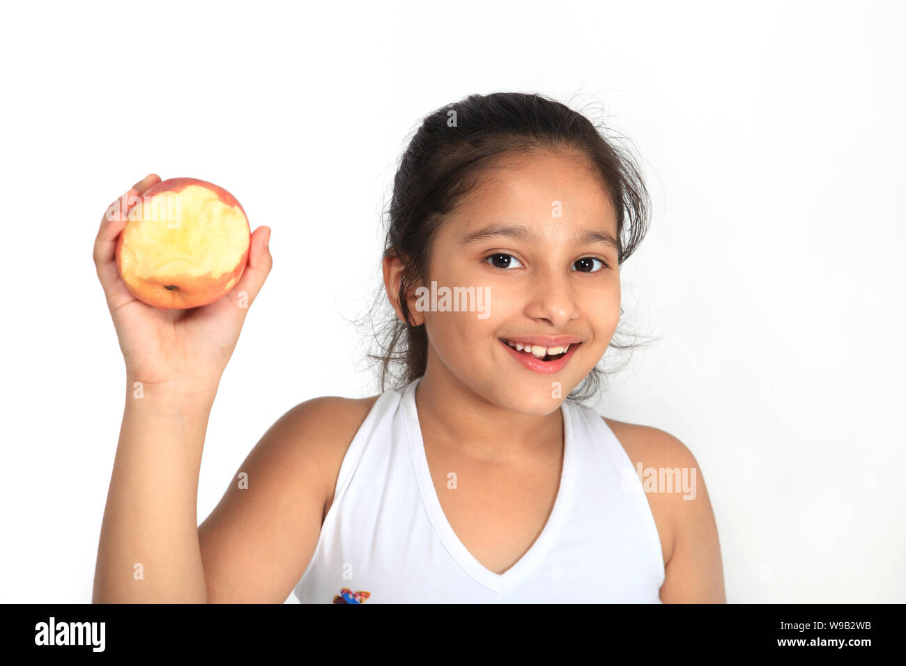 Girl eating an apple and smiling Banque D'Images