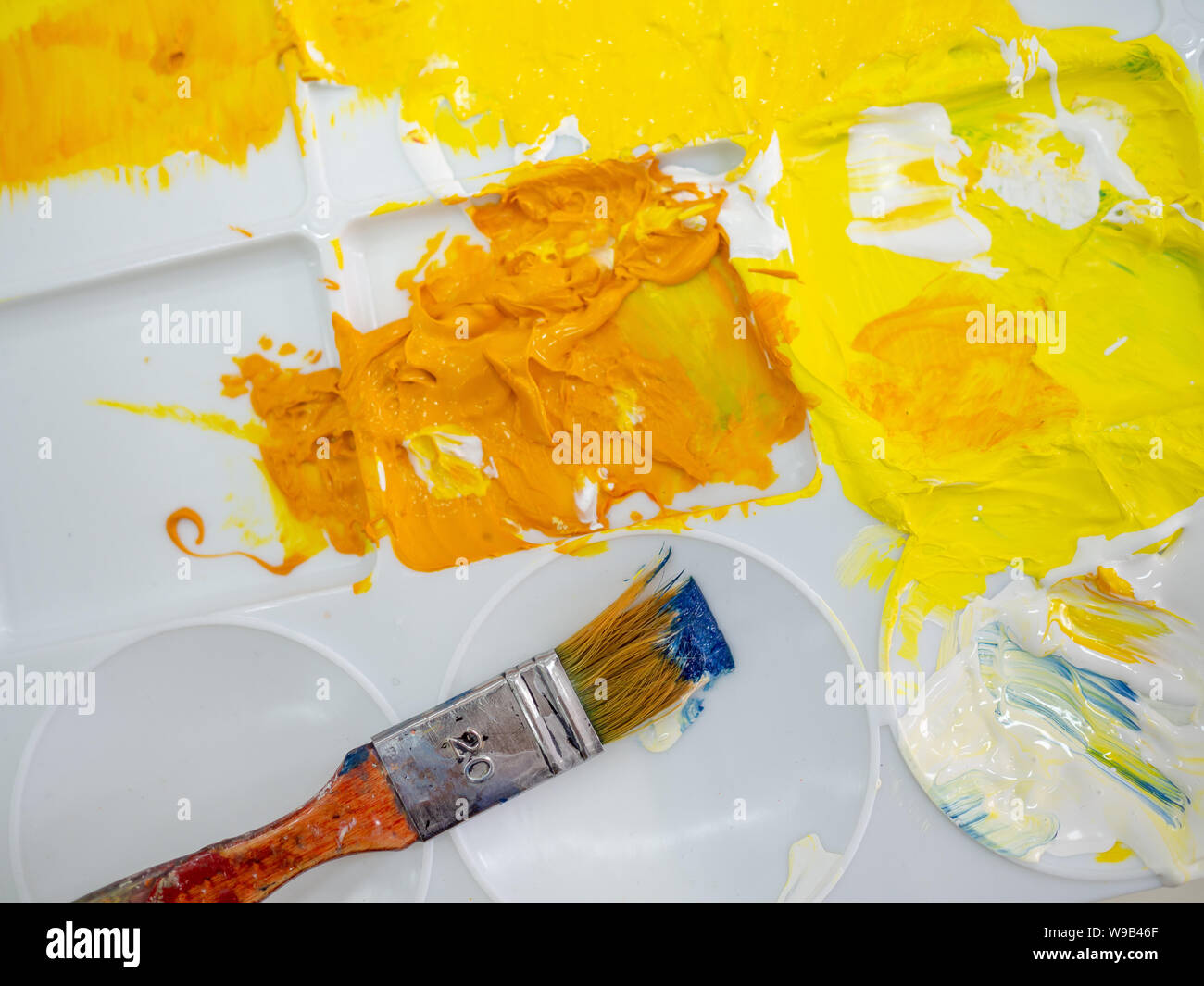 Pinceau de l'artiste sur l'artiste en plastique blanc avec palette couleur acrylique jaune vue d'en haut. Banque D'Images Pinceau de l'artiste sur l'artiste en plastique blanc avec palette couleur acrylique jaune vue d'en haut. Banque D'Images
