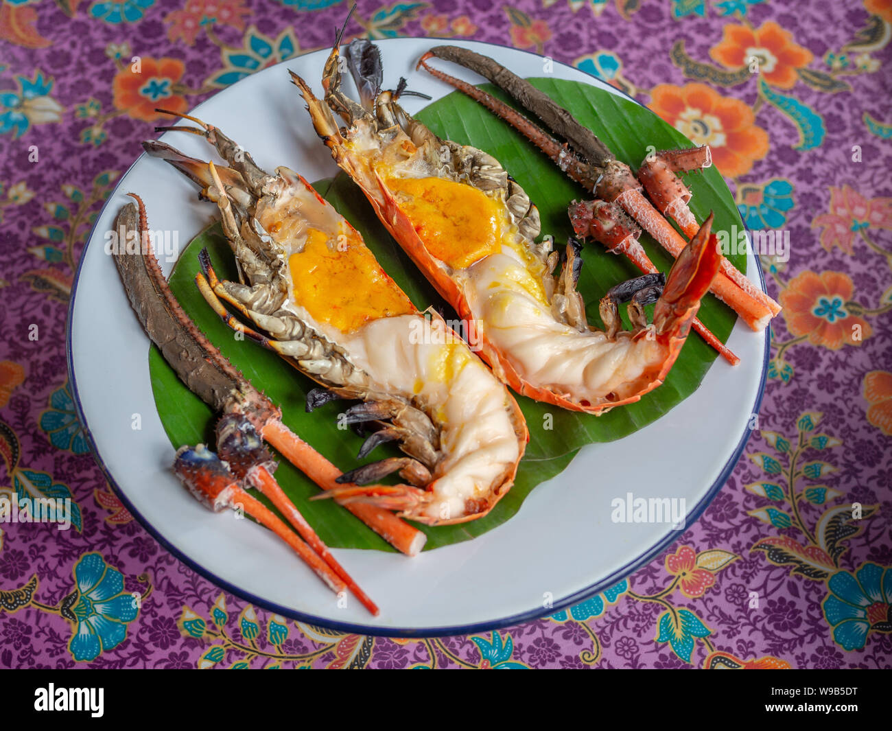 Crevettes géantes grillées rôti à la crevette sur la rivière ou sur des feuilles de banane verte vintage blanc plat sur tissu magnifique style Thaï. L'alimentation de style thaï avec Thai Banque D'Images