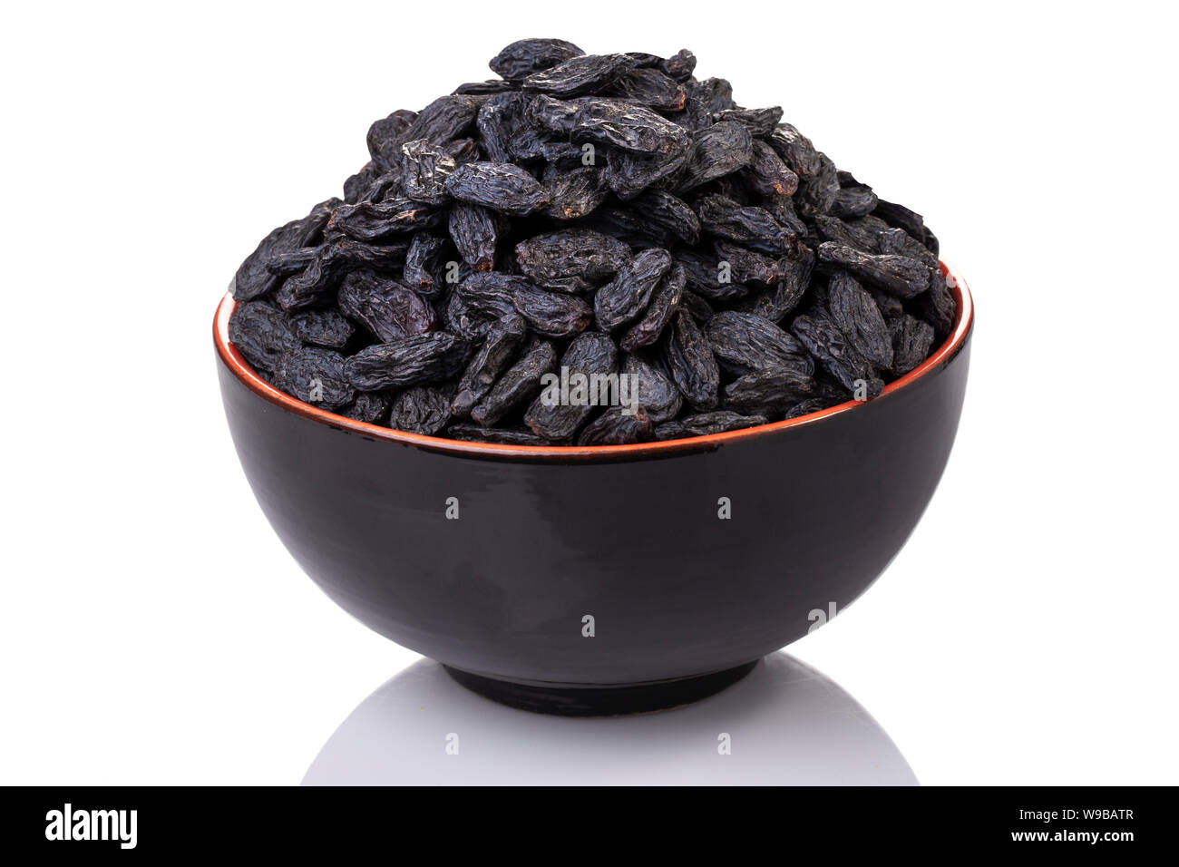 Raisins noirs dans un noir et l'orange bowl Banque D'Images