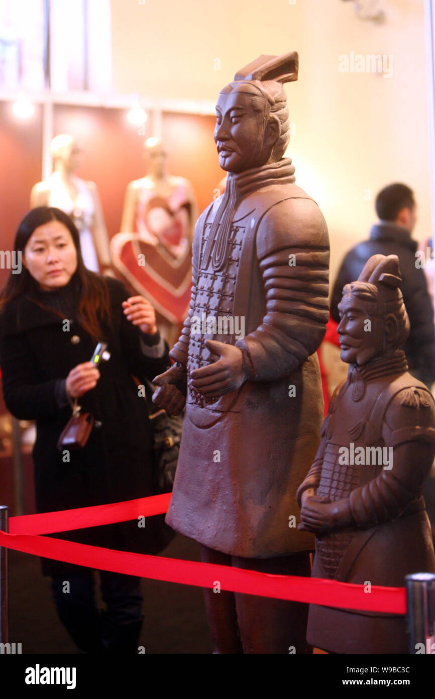 Les visiteurs regarder-chocolat fait des répliques des guerriers de terre cuite pendant le salon du chocolat, Salon du Chocolat, à Shanghai, Chine, 21 janvier 2010. Banque D'Images