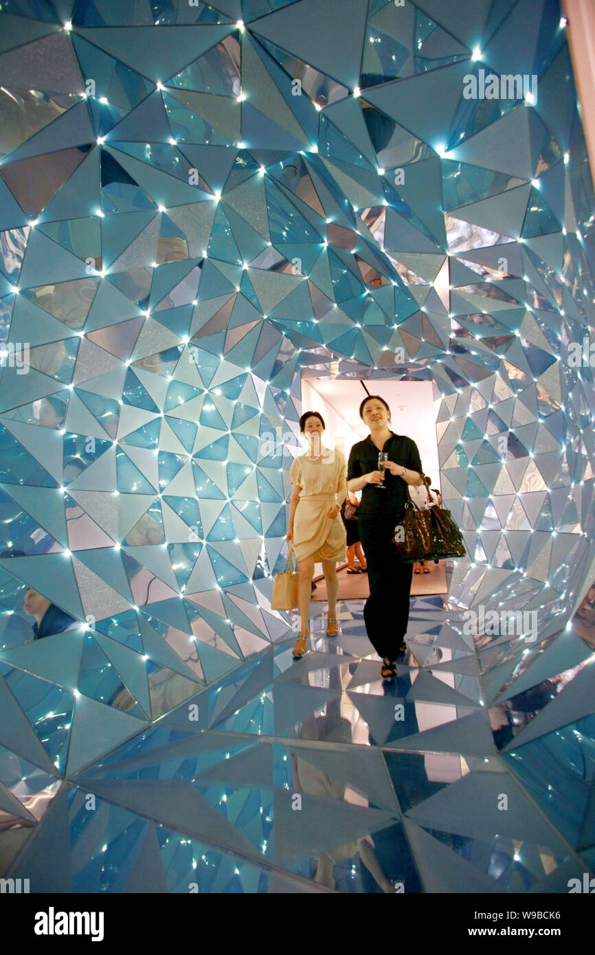 Les visiteurs marchent à travers un tunnel dans le cristal Swarovski Crystal Palace à l'hôtel Fairmont Peace Hotel à Shanghai, Chine, 12 août 2010. Crystal bouilloire Banque D'Images