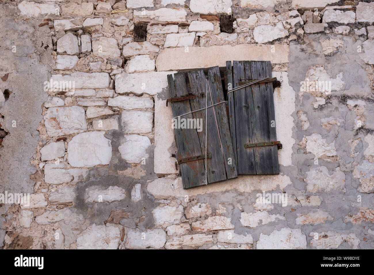 Dans l'ancien bâtiment du centre historique de la ville, fait de pierres afin d'éviter que la chaleur. Fenêtre avec un volet fermé. Sibenik, Croatie. Banque D'Images